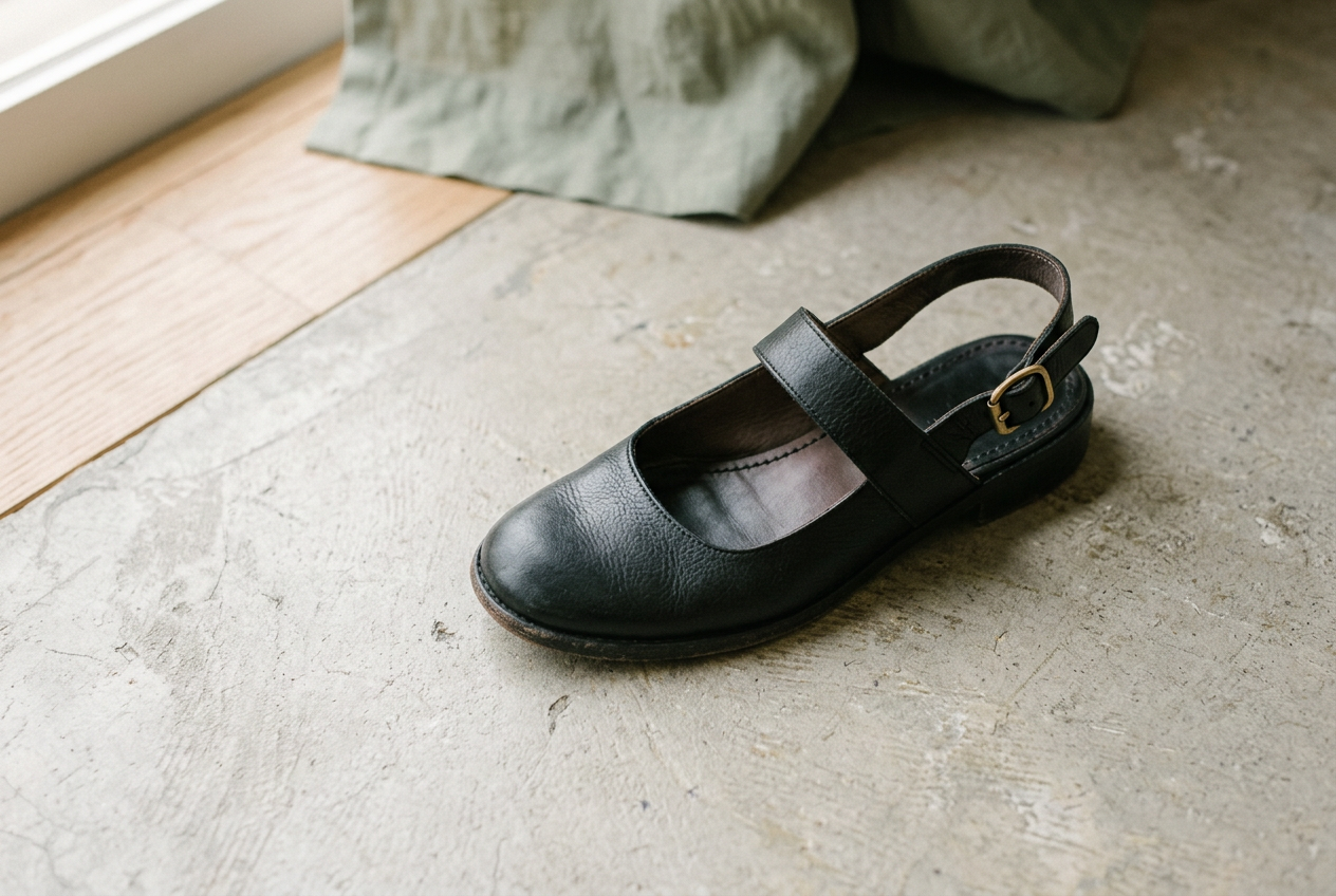 Black leather slingback peep-toe shoes showing a broad rounded rectangular toe opening.